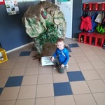 chłopiec klęczy przy dinozaurze.jpg