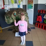 dziewczynka stoi i głaszcze dinozaura.jpg