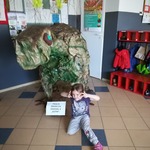 dziewczynka siedzi przy dinozaurze.jpg